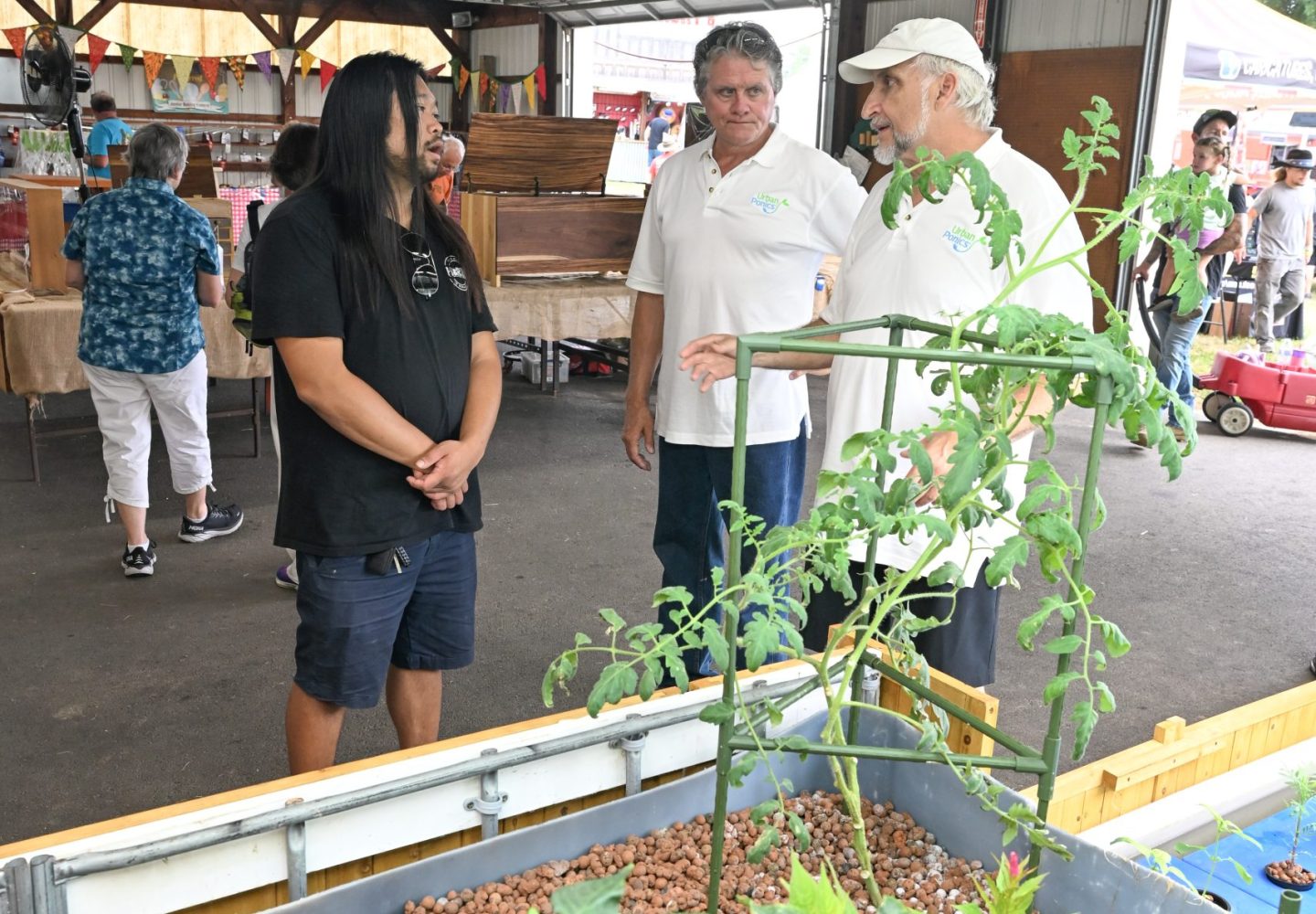 Webb & Bill chatting with attendee about the merits of hydroponic farming.